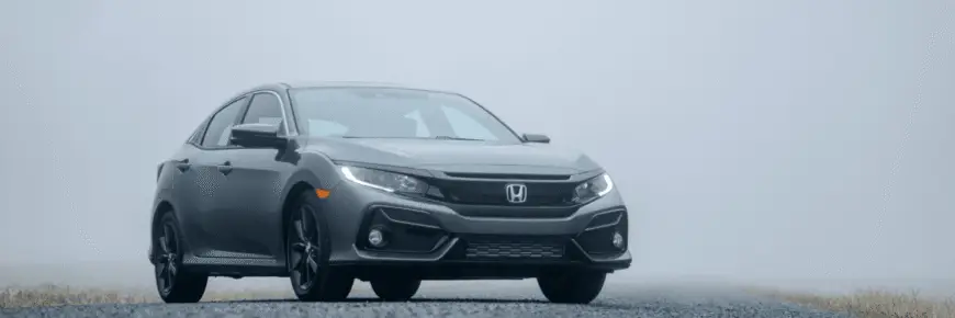 Automotive Repair & Tire Shop Oakville, ON - Sil’s Auto Care Centre A grey Honda saloon parked on an empty road surrounded by fog, with low visibility and a faint suggestion of grass on either side—perfect for drivers seeking a reliable drive or searching for a Honda Service Centre Near Me. | Call Us Today At +1 (905) 823-2626