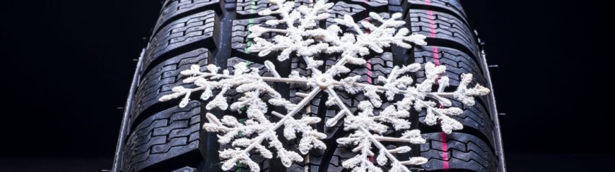 Automotive Repair & Tire Shop Oakville, ON - Sil’s Auto Care Centre A close-up of a winter tyre shows a white snowflake decoration resting on its tread pattern, highlighting the tyre's suitability for snowy or icy conditions. | Call Us Today At +1 (905) 823-2626