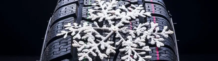 Automotive Repair & Tire Shop Oakville, ON - Sil’s Auto Care Centre A close-up of a winter tyre shows a white snowflake decoration resting on its tread pattern, highlighting the tyre's suitability for snowy or icy conditions. | Call Us Today At +1 (905) 823-2626