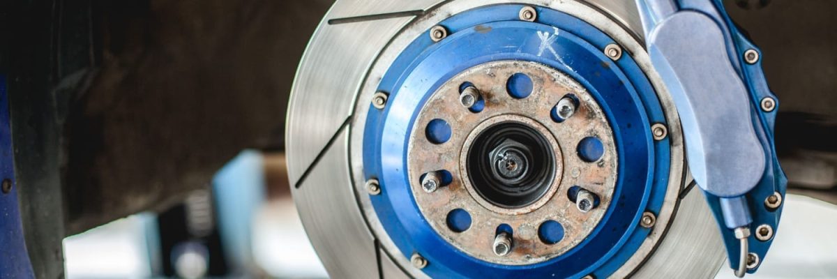 Automotive Repair & Tire Shop Oakville, ON - Sil’s Auto Care Centre Close-up of a car's disc brake system with a silver brake disc, blue fittings, and a blue calliper. The image highlights the clean look and details—ideal for those searching for professional Brake Repair Near Me. | Call Us Today At +1 (905) 823-2626